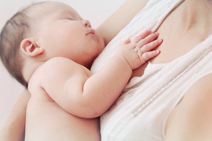 Schlafendes Baby an Mutters Brust